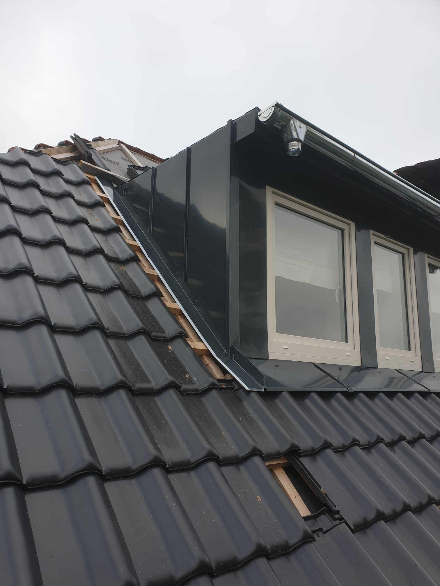Gaube mit Metalldach und dunklen Dachziegeln